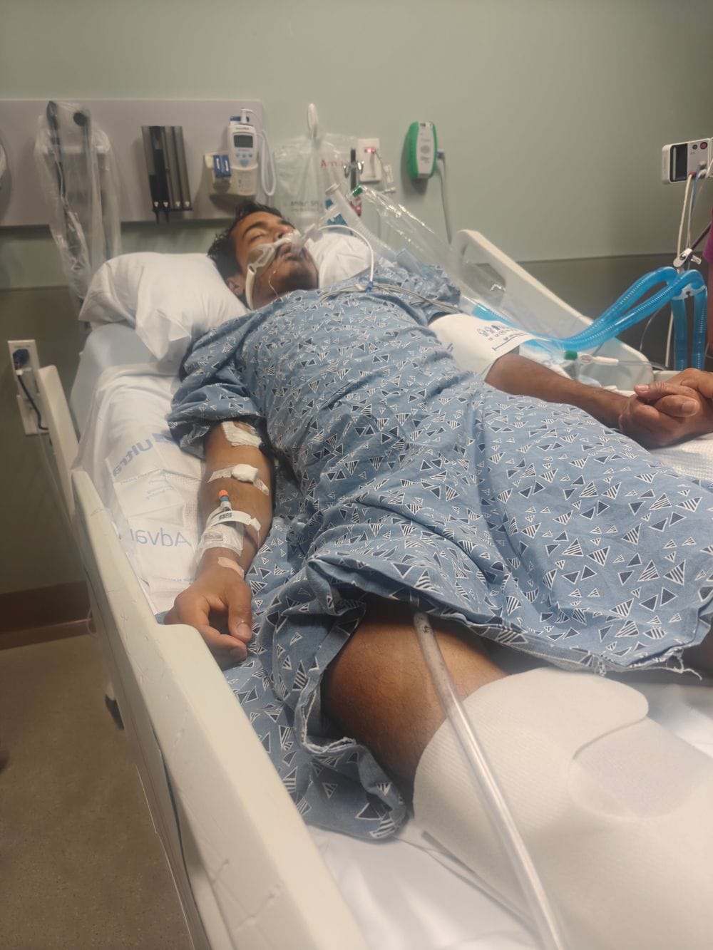 A hand holding Karamat's at his bedside while he was unconscious